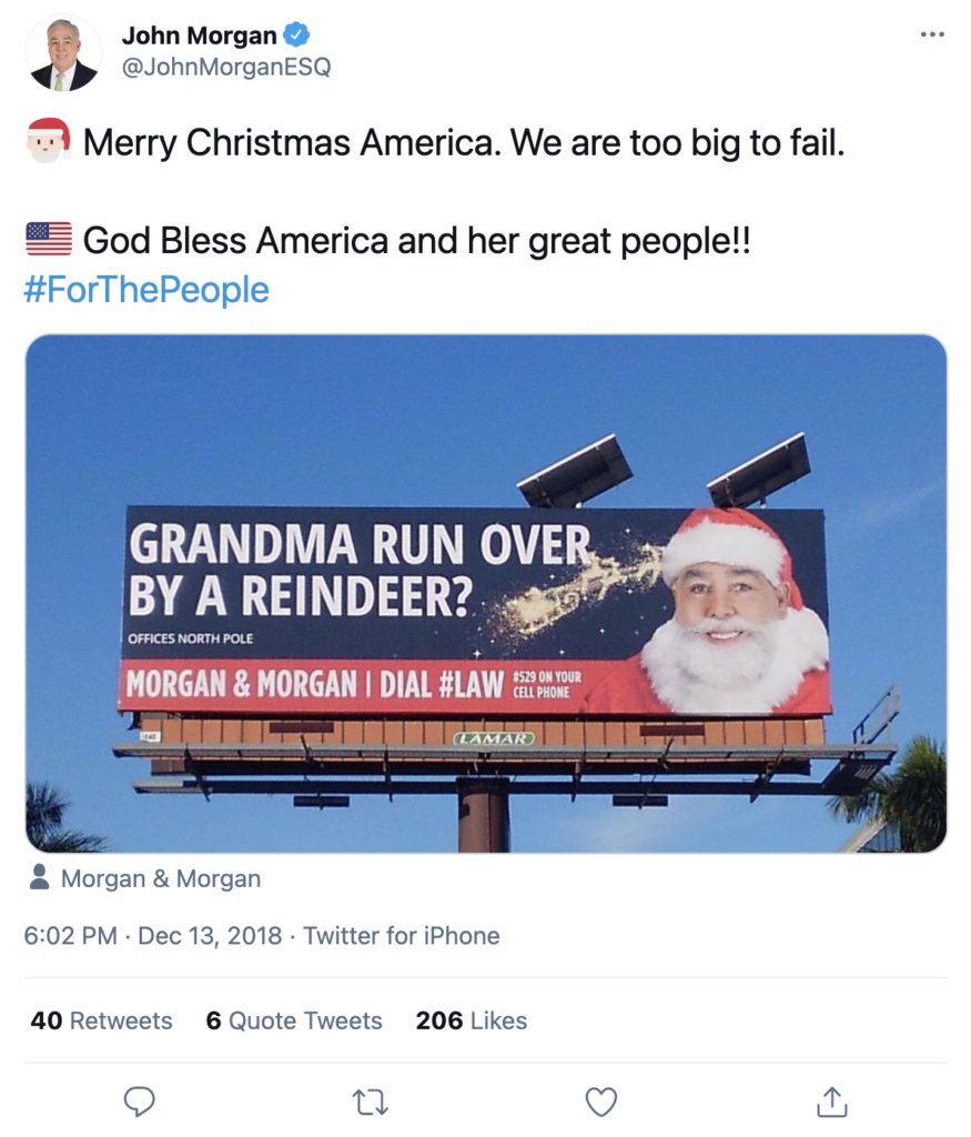 A screenshot of a tweet by John Morgan. The tweet features a billboard with John Morgan as Santa Claus and the copy "Grandma Run Over By A Reindeer?"